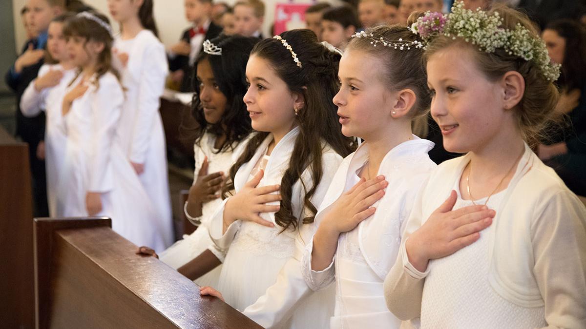 Kommunionkinder während der Feier der Erstkommunion in der Kirche St. Pankratius in Köln-Worringen